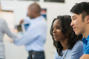 Two colleagues looking at a computer screen together.
