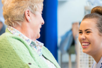 Care support worker talking and smiling with a patient.