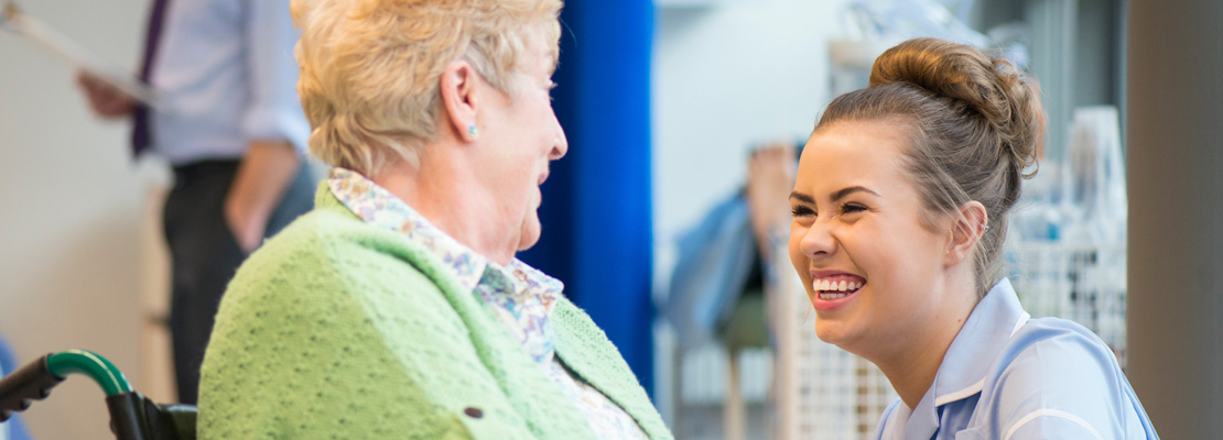 Care support worker talking and smiling with a patient.