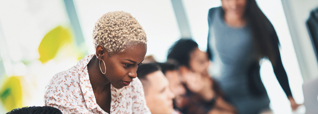 Woman helping a colleague in an office environment.