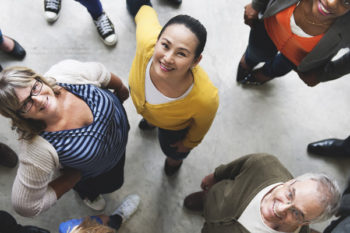 Aerial shot of office workers smiling up at the camera.