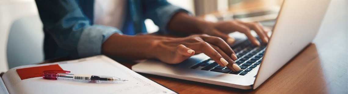 Close up of someone typing on a laptop keyboard