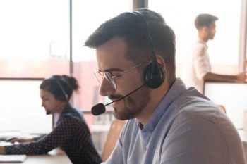 Man working in a call centre wearing a headset.