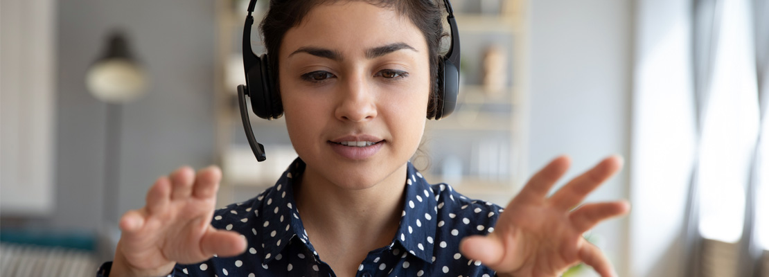 Woman speaking on a video call wearing headphones