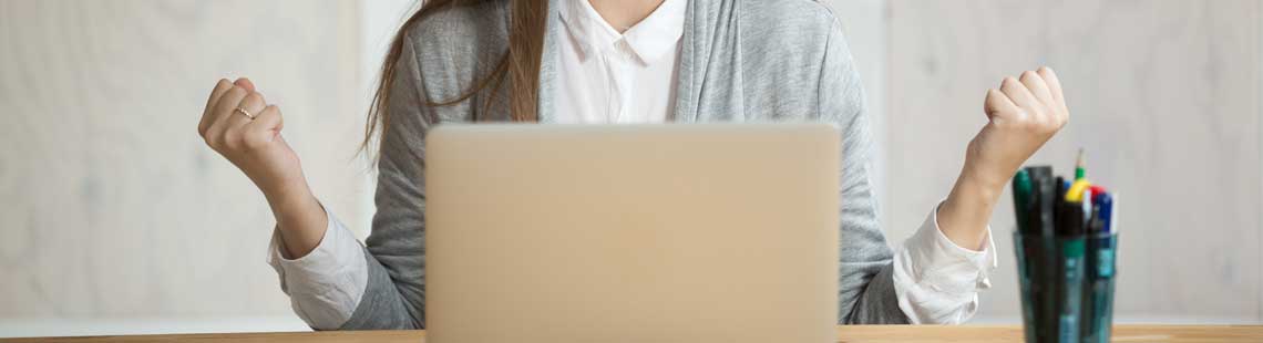Someone celebrating while looking at a laptop.