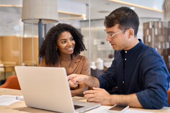 Two people discussing at a laptop