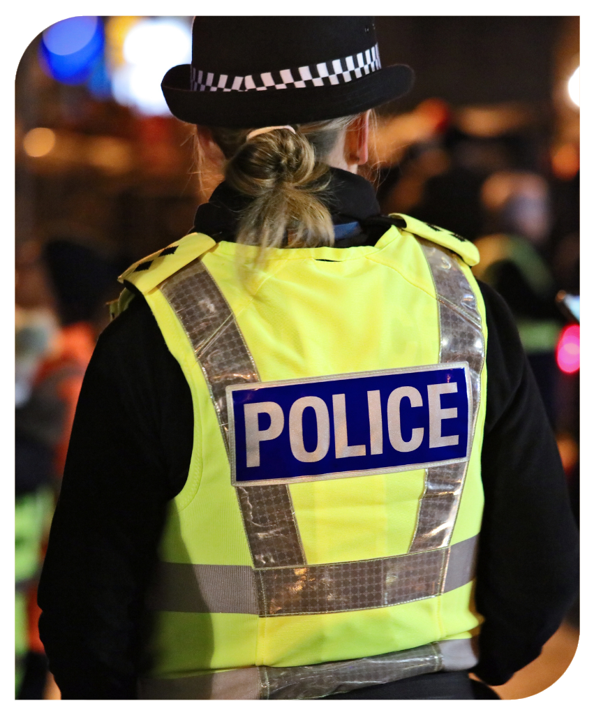 Back of police officer in uniform at night.